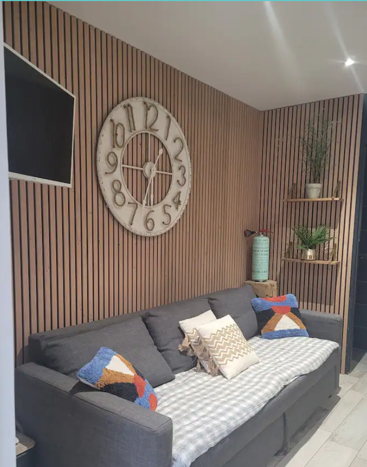 Photo d'un salon cosy avec canapé et mur en bois